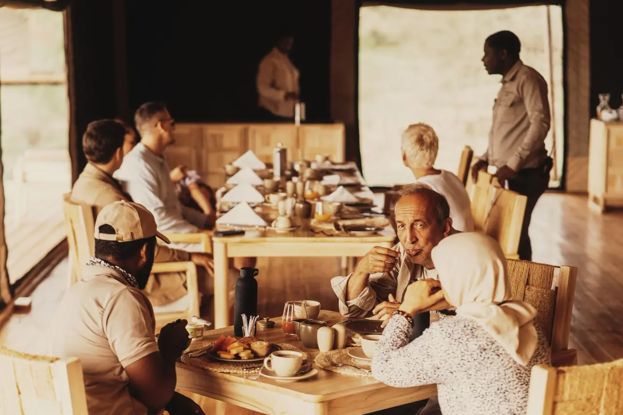 Guests and staff at breakfast in the open-sided mess tent at Conserve Safari Tarangire