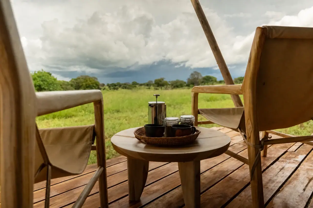 Coffee service on a private tent veranda overlooking the Tarangire grassland under a storm sky