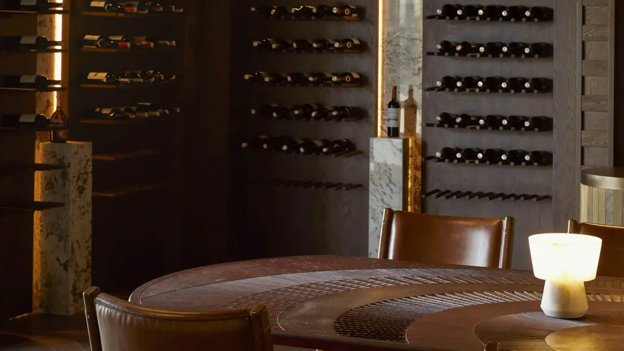 Wine cellar dining table surrounded by stocked wine racks at Four Seasons Safari Lodge Serengeti