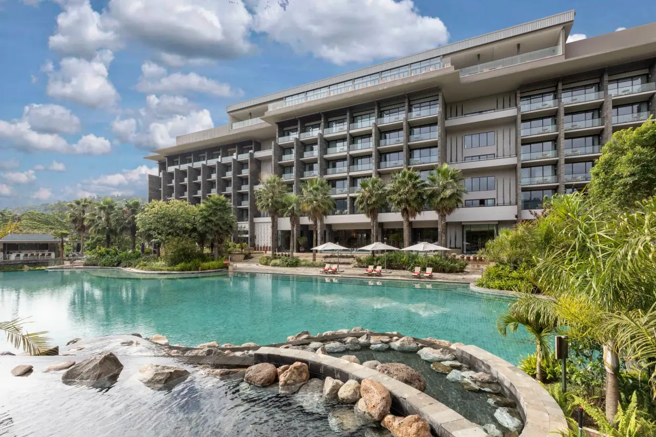 Gran Melia Arusha hotel exterior with multi-storey guest wing overlooking the free-form swimming pool and palm gardens