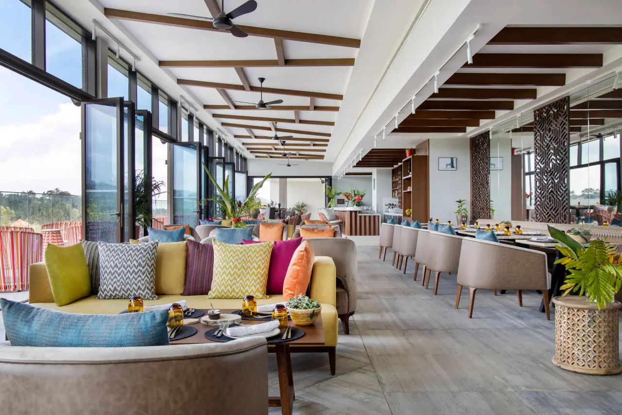 Open-air restaurant and lounge at Gran Melia Arusha with colourful cushioned seating and floor-to-ceiling windows