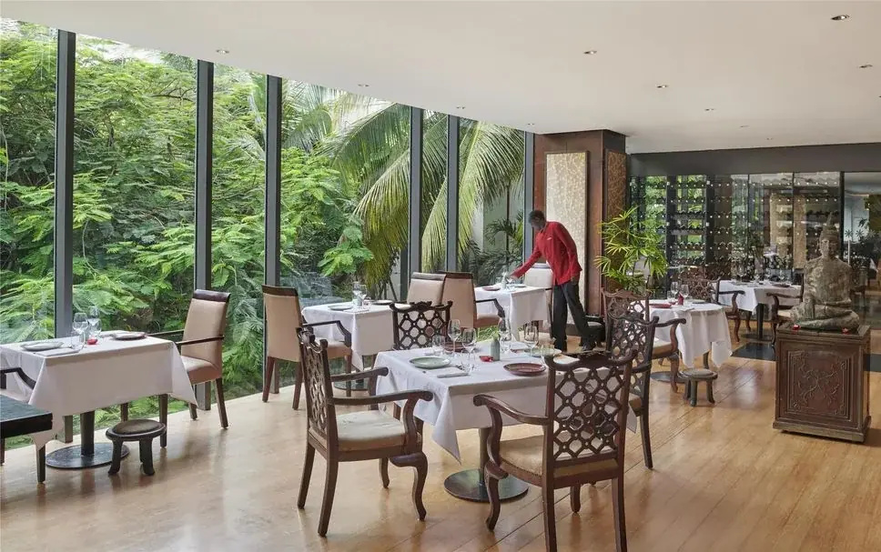 Glass-walled restaurant at Hyatt Regency Dar es Salaam overlooking a lush tropical garden