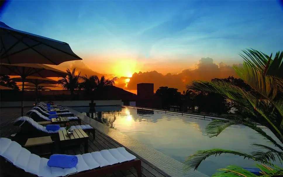 Rooftop infinity pool at Hyatt Regency Dar es Salaam with loungers facing a golden sunset over the city