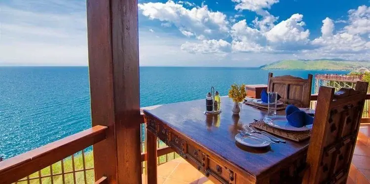 Private balcony dining table at Kigoma Hilltop overlooking Lake Tanganyika and the surrounding hills