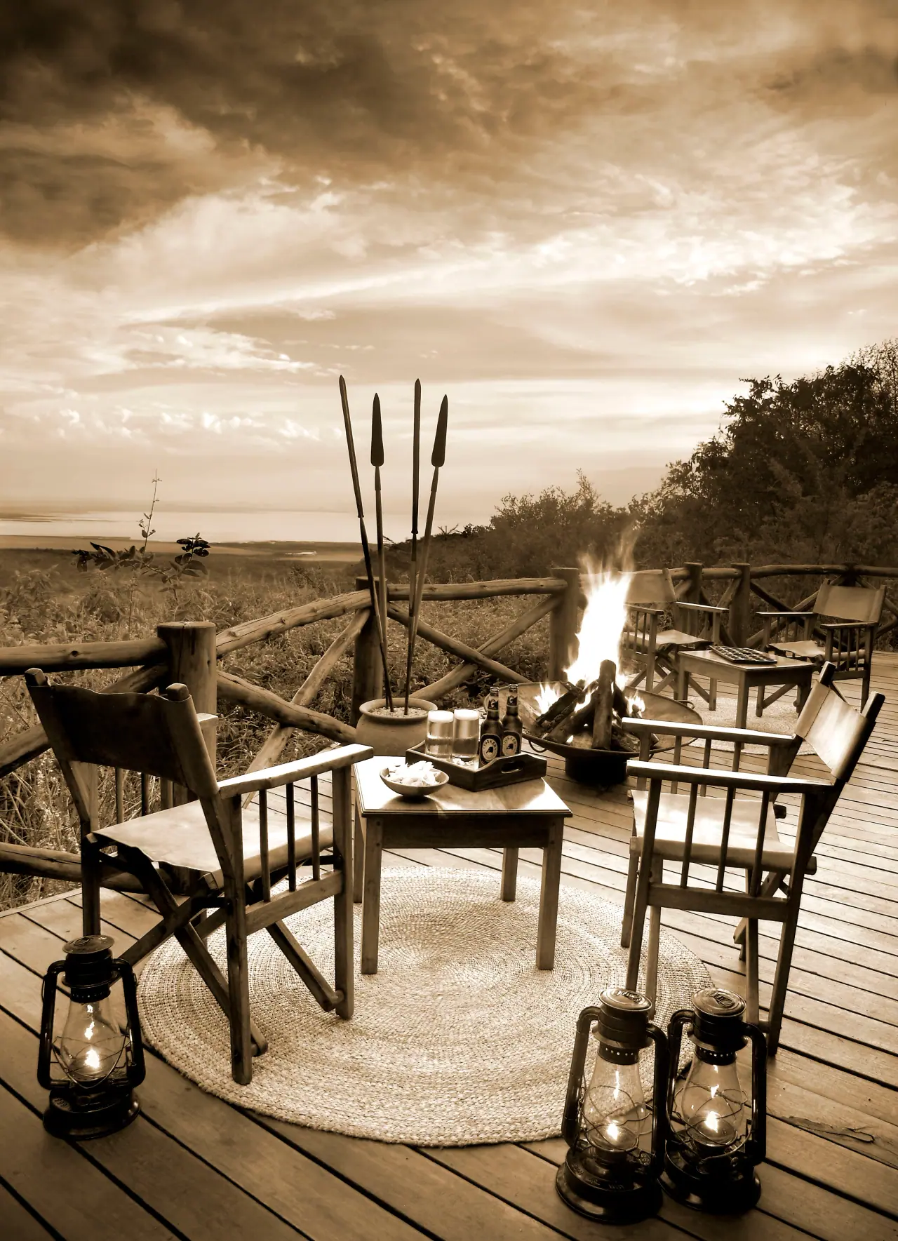 Evening fire pit lounge with director's chairs and safari lanterns on the deck at Kirurumu Manyara Lodge