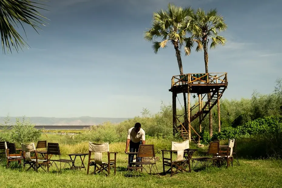 Elevated wooden lookout tower beneath doum palms overlooking Lake Eyasi at Kisima Ngeda Tented Camp