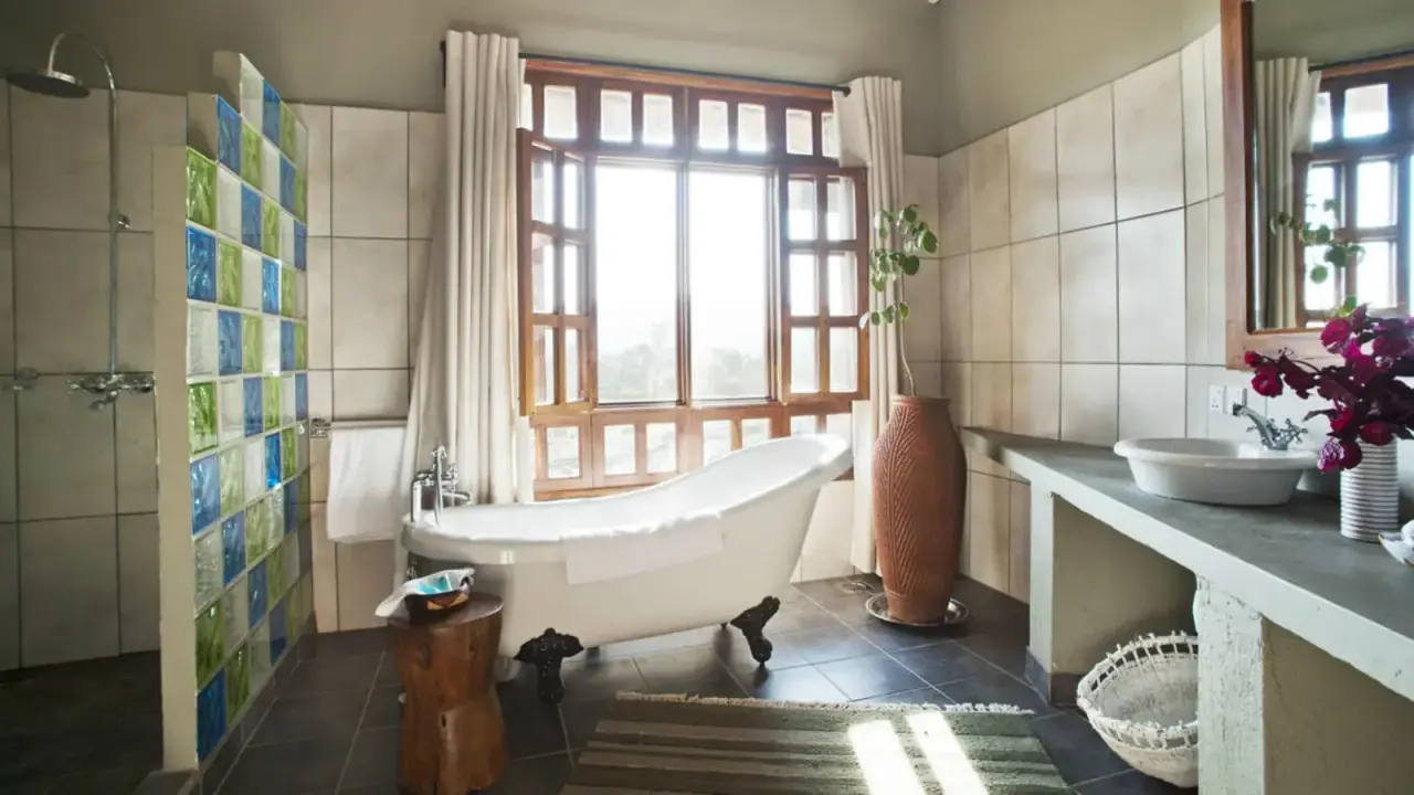 En-suite bathroom at Kitela Lodge with a freestanding clawfoot tub and glass-block shower