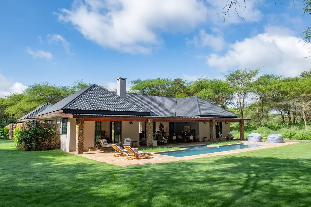 The main house beside its swimming pool and lawn