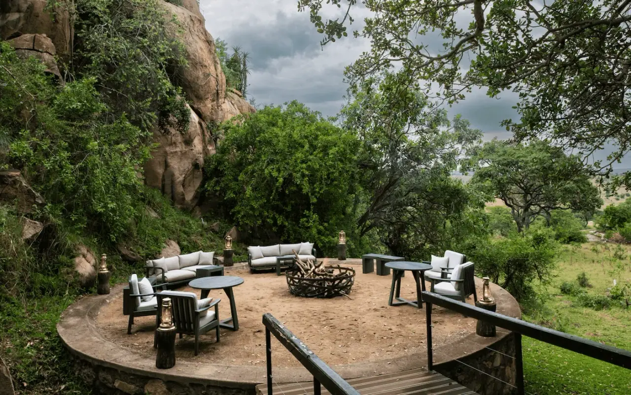 Outdoor lounge with fire pit built into the rocks overlooking the plains at Lemala Kuria Hills