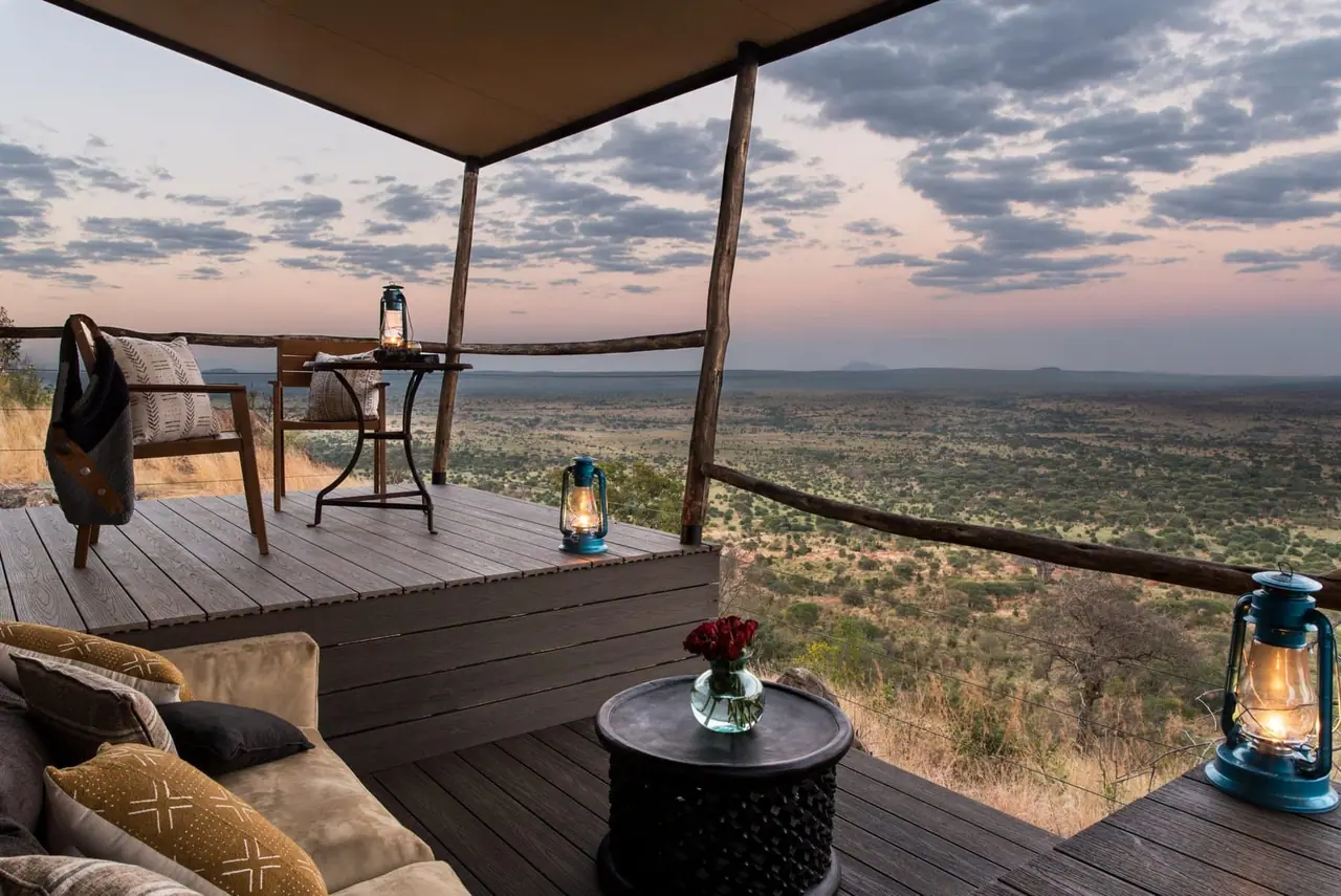 A private deck with lounge seating and lanterns at sunset above the valley