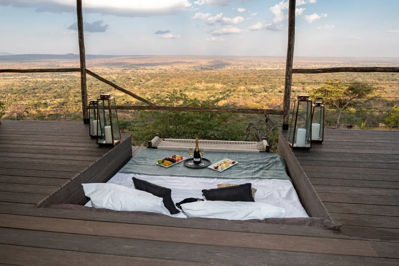 A sunken outdoor lounge with a daybed on a suite deck above the valley