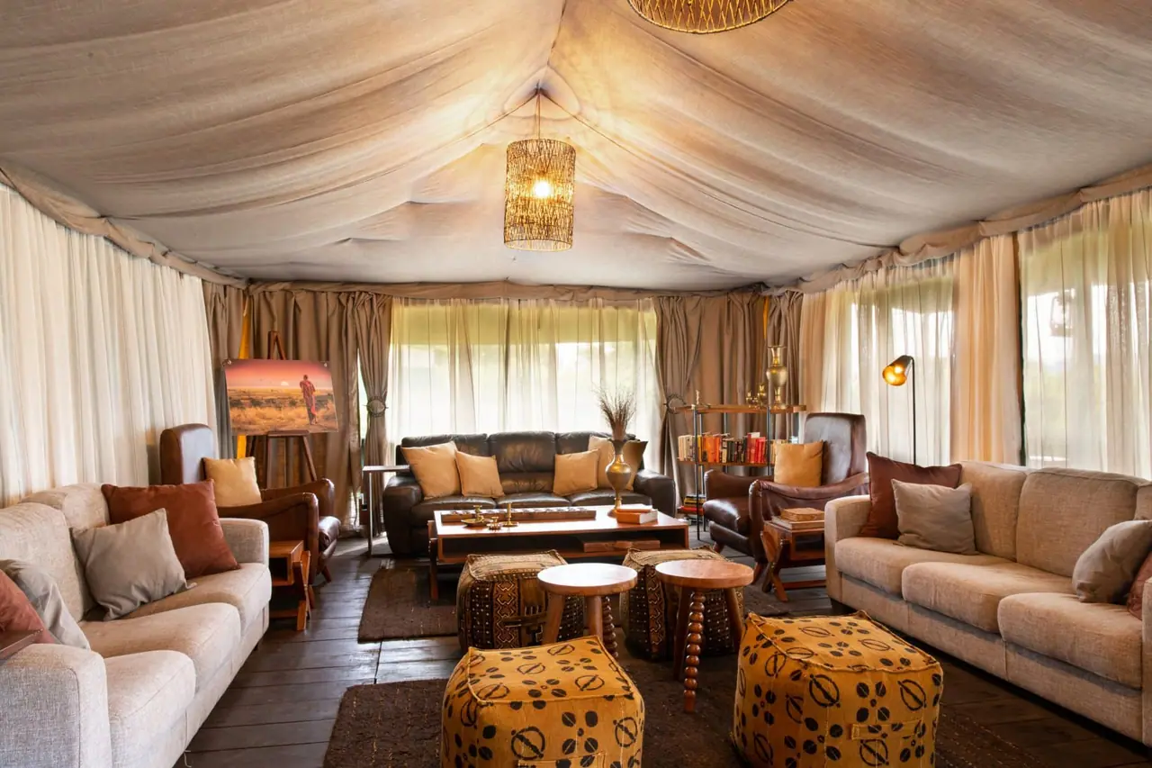 The lounge in the mess tent with sofas, lamps and patterned stools