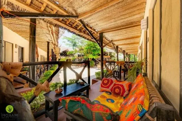Covered veranda lounge at Makofi Guest House with colorful African-print cushions and a thatched ceiling