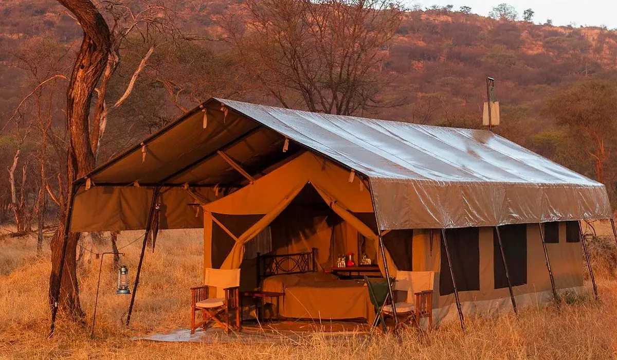Guest tent at Ndutu Kati Kati Tented Camp lit by golden-hour light against the Ndutu hillside