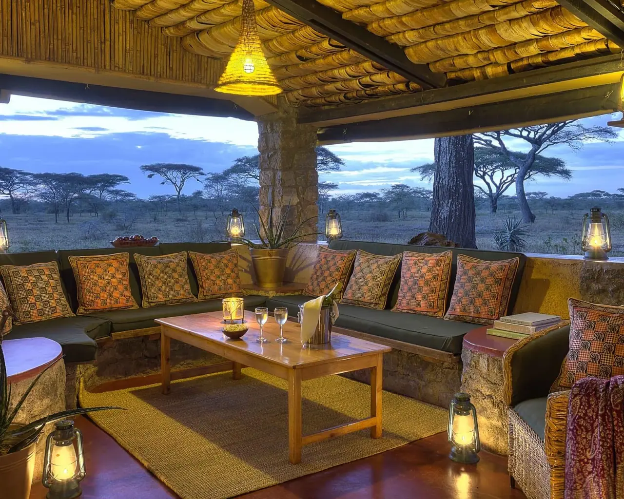 Lantern-lit lounge terrace at Ndutu Safari Lodge overlooking the Serengeti plains at dusk