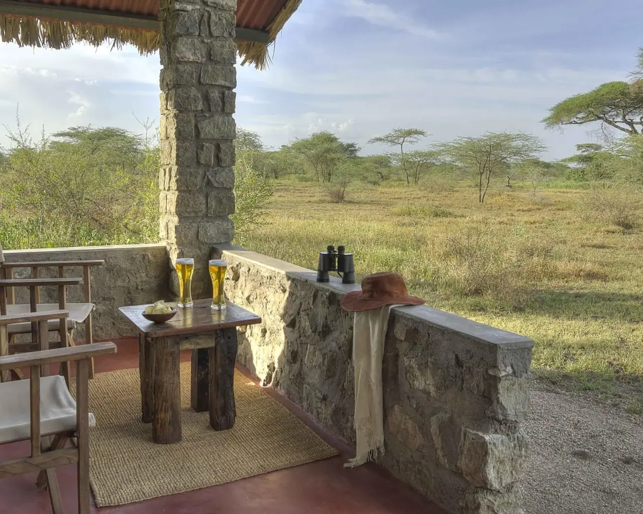 Private veranda at Ndutu Safari Lodge with chilled drinks and binoculars overlooking the plains