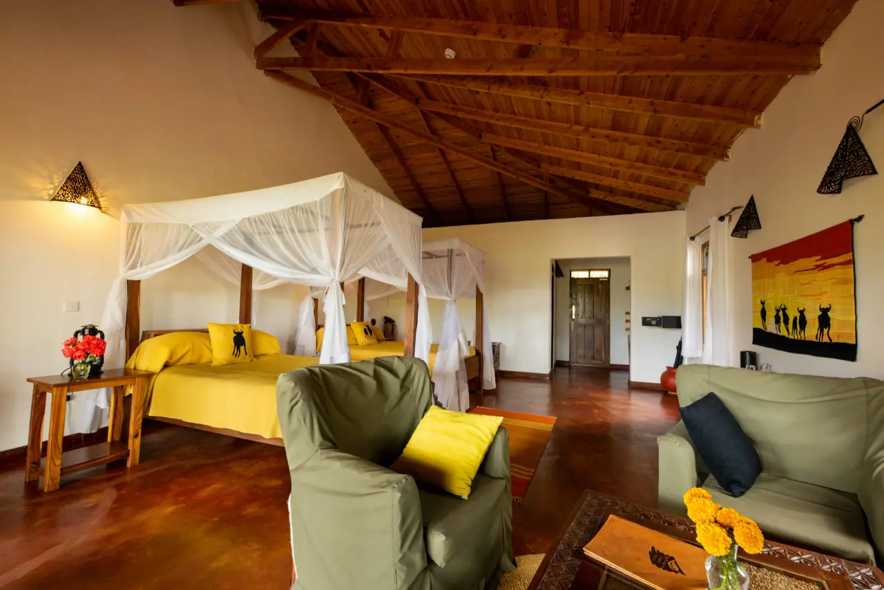 Twin four-poster beds under mosquito nets in a guest room at Ngorongoro Farm House