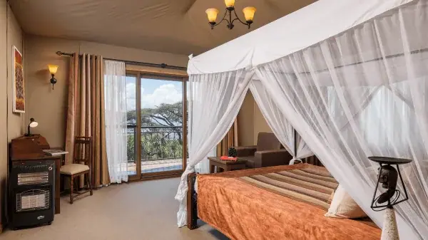 Canopy bed guest room at Ngorongoro Lion's Paw with a private balcony view