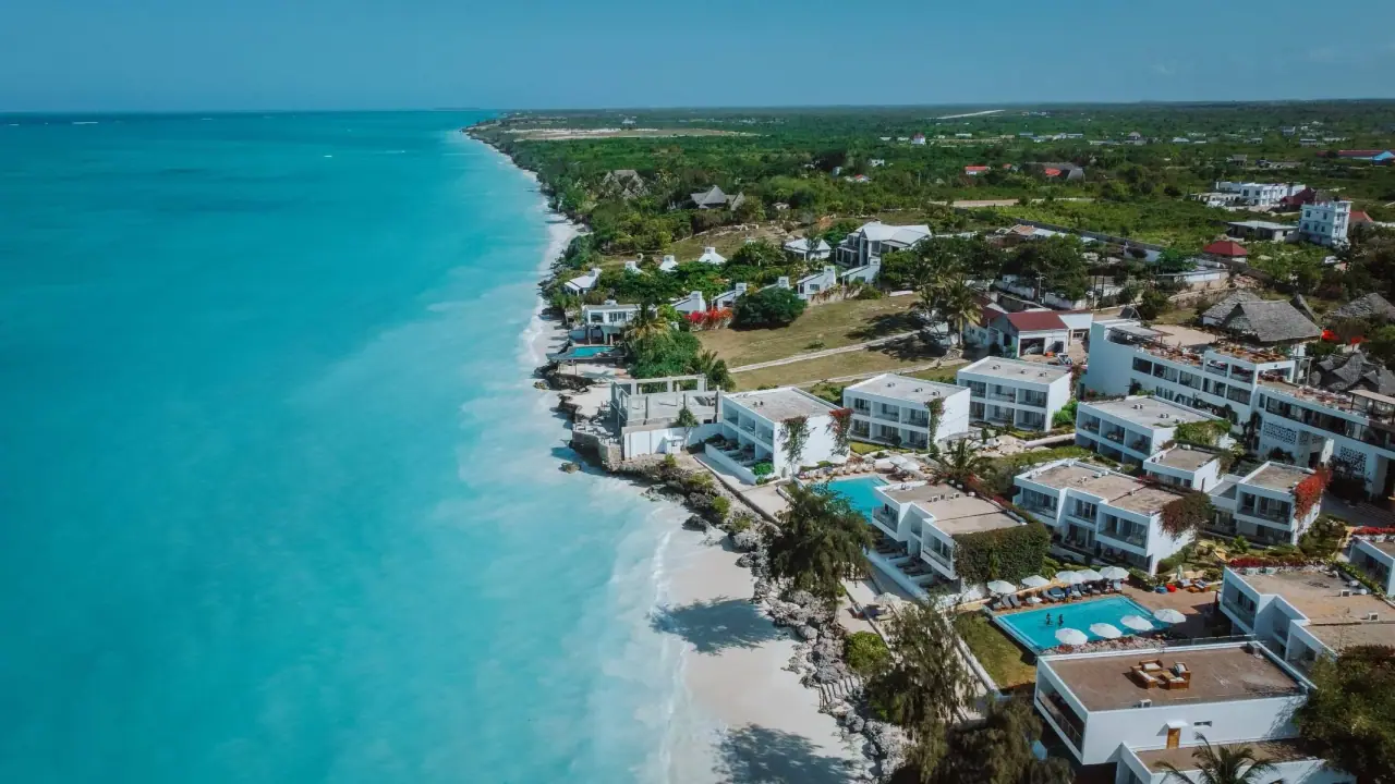 Aerial view of Nungwi Dreams By Mantis's white beachfront villas and pools strung along the Nungwi coastline