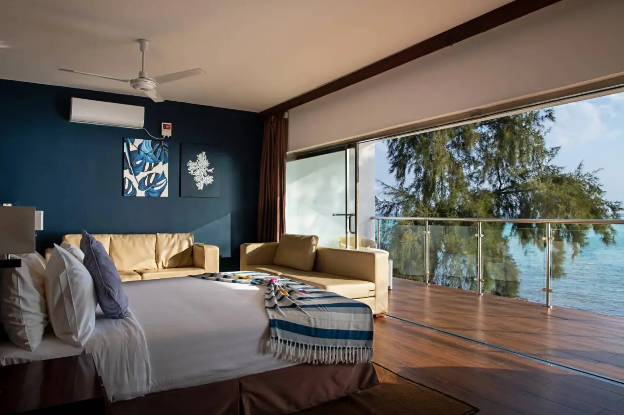 Ocean-view suite bedroom with a private balcony overlooking the sea at Nungwi Dreams By Mantis
