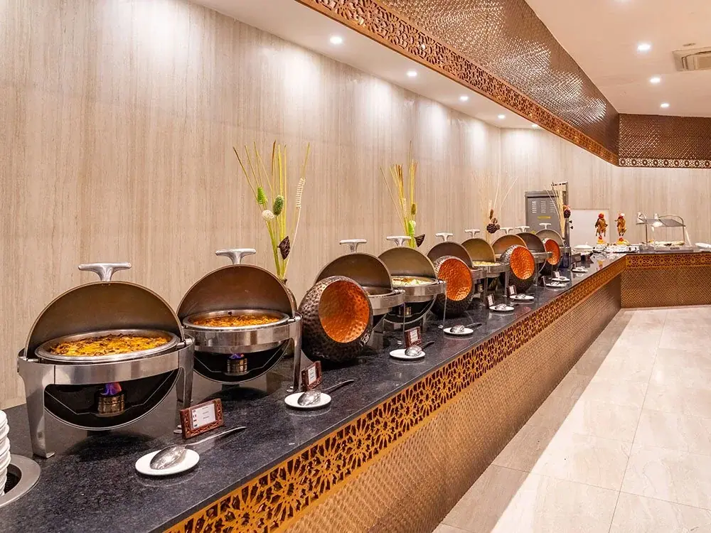 Buffet restaurant with chafing dishes and copper accents at Royal Zanzibar