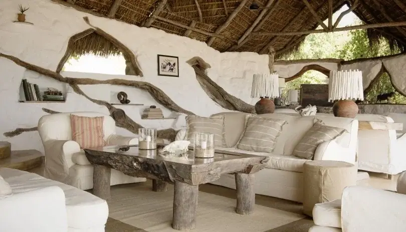 Living area with driftwood decor and white sofas at Sand Rivers Selous