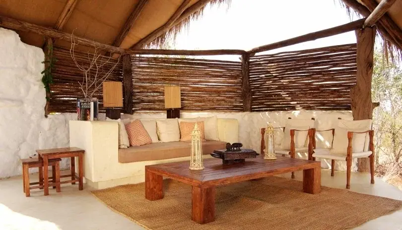 Whitewashed stone lounge with wicker furniture at Sand Rivers Selous
