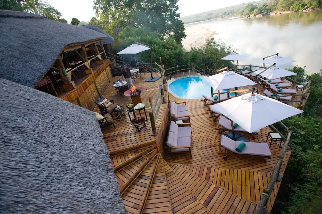 Aerial view of the wooden pool deck and loungers above the Rufiji River at Serena Mivumo River Lodge