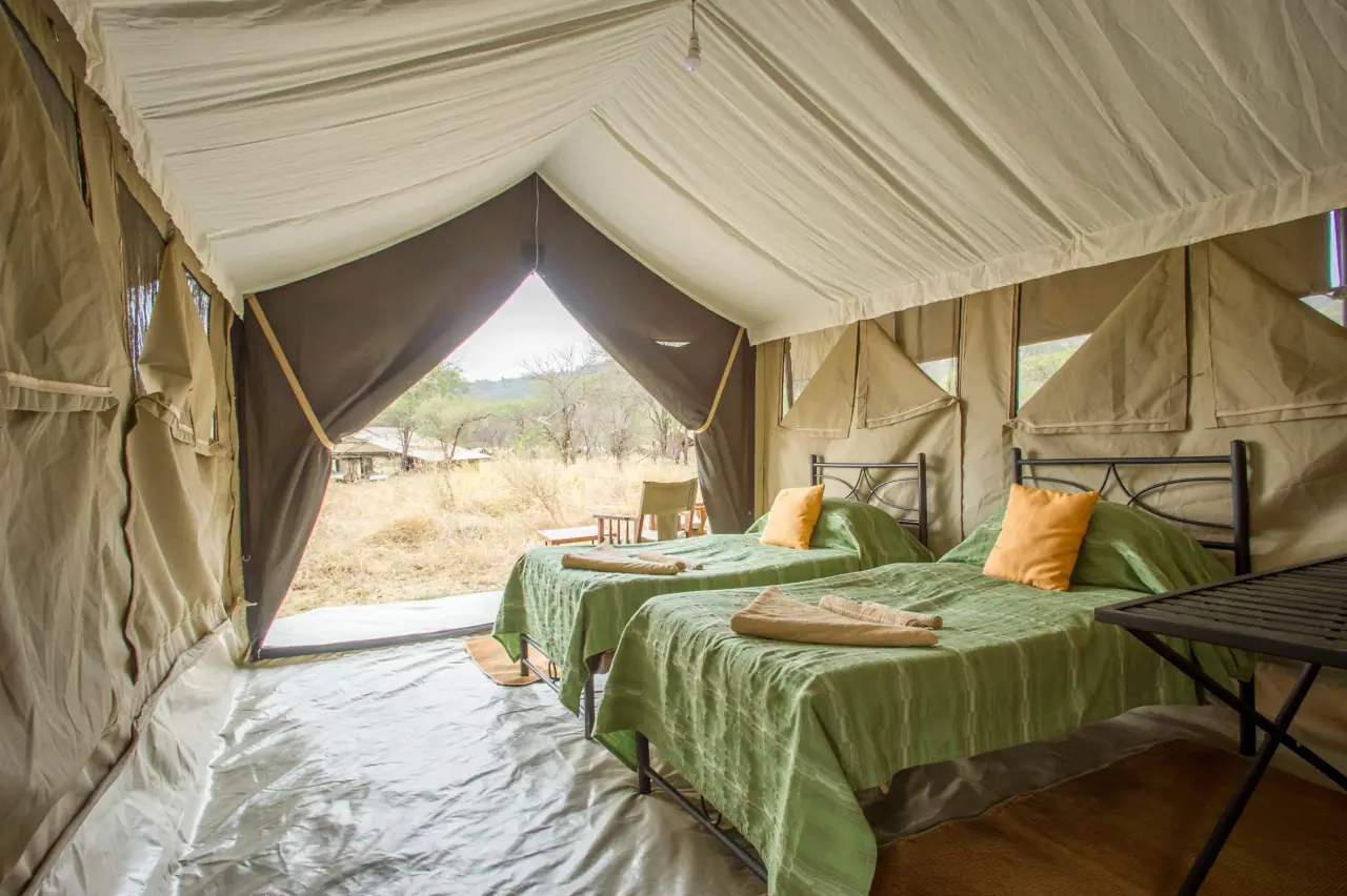 Twin-bed tent interior opening onto the Serengeti plains at Serengeti Katikati Camp