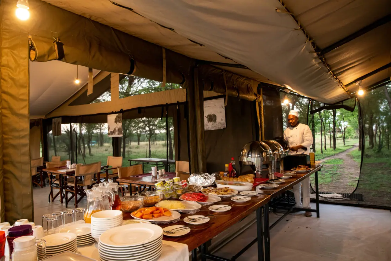 Chef preparing a breakfast buffet spread inside the mess tent at Serengeti Katikati Camp
