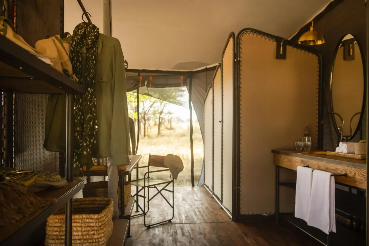 Walk-in closet and en-suite bathroom vanity with double sinks inside a tent at Siringit Migration Camp