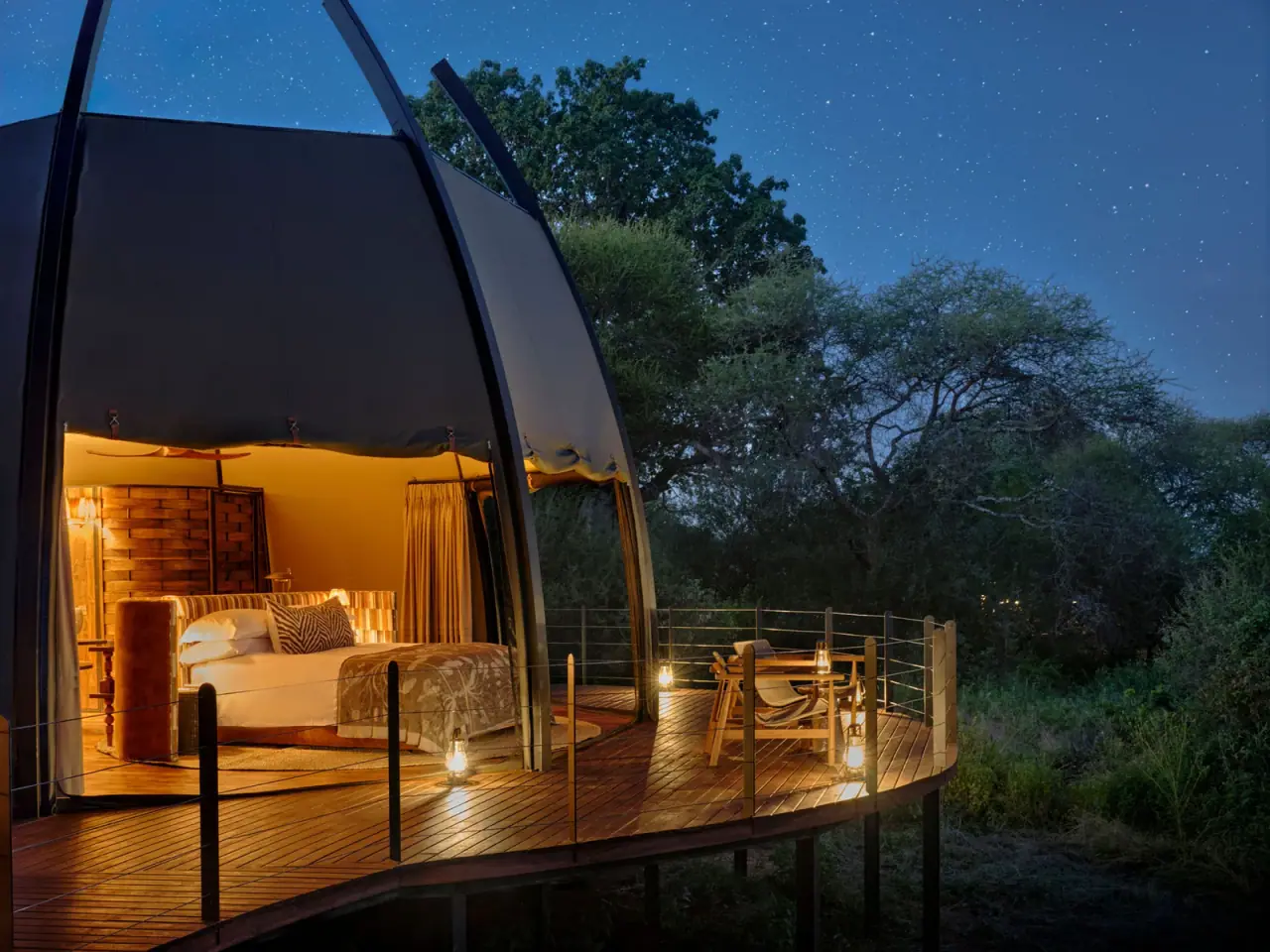 Domed guest suite at Siringit Tarangire Camp with bed and private deck under a starry night sky