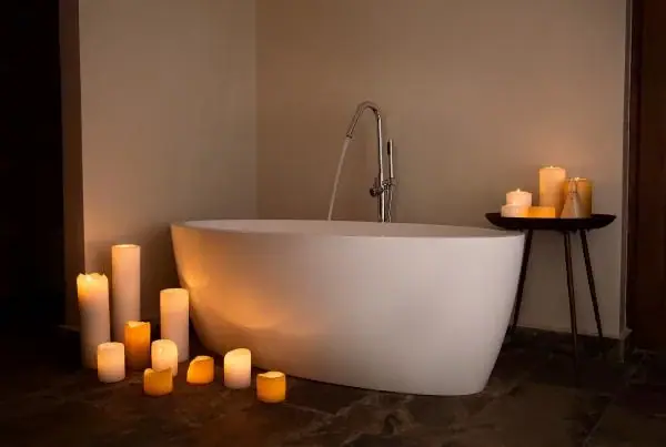 Freestanding bathtub surrounded by lit candles in a bathroom at Siringiti Arusha Villa