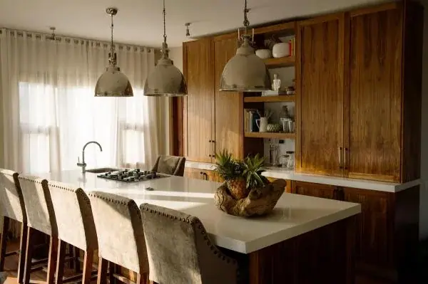 Modern kitchen at Siringiti Arusha Villa with wooden cabinetry, pendant lights and a breakfast bar
