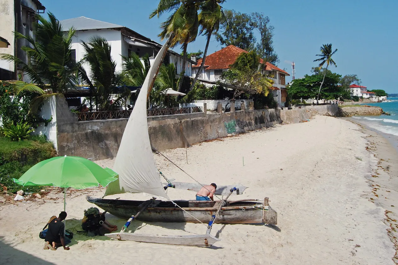 The beach in front of the Zanzibar Serena Inn, with an outrigger boat pulled up on the sand beneath palms