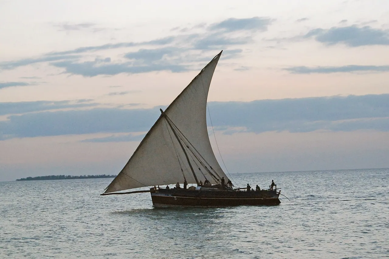 A dhow with a lateen sail crossing the sea in view of the Zanzibar Serena Inn