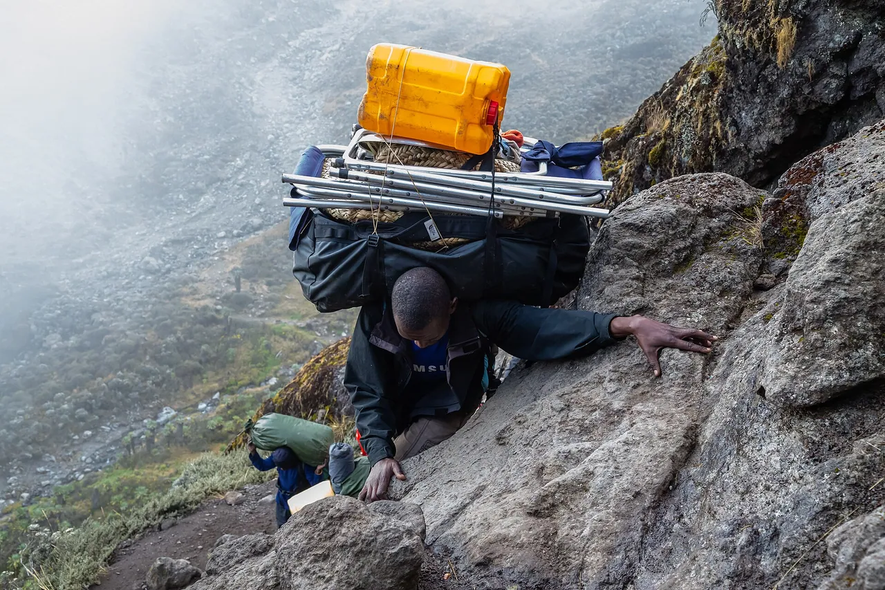 Porters carrying loads up the rocky Barranco Wall