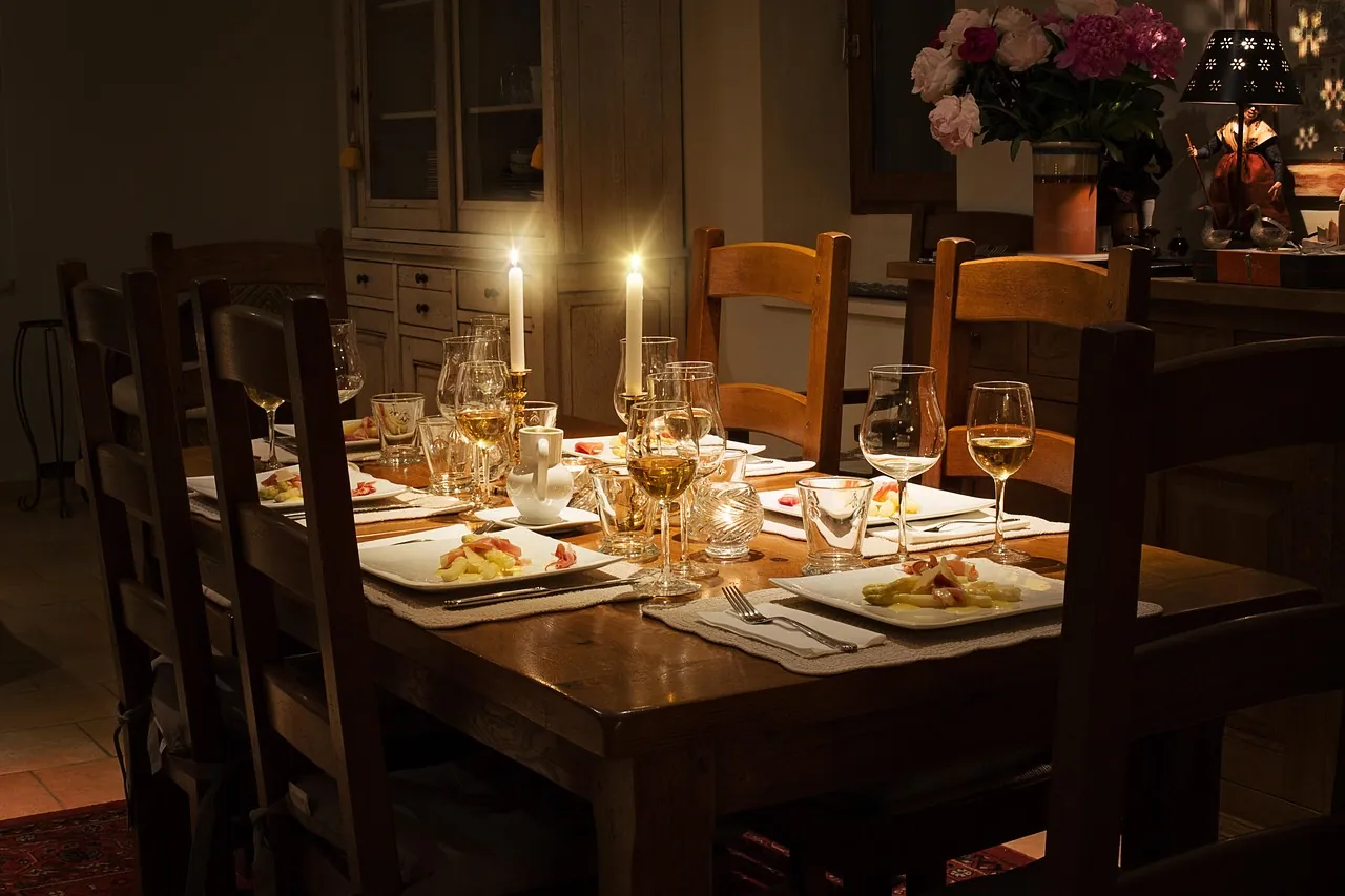 A dining table laid for dinner by candlelight