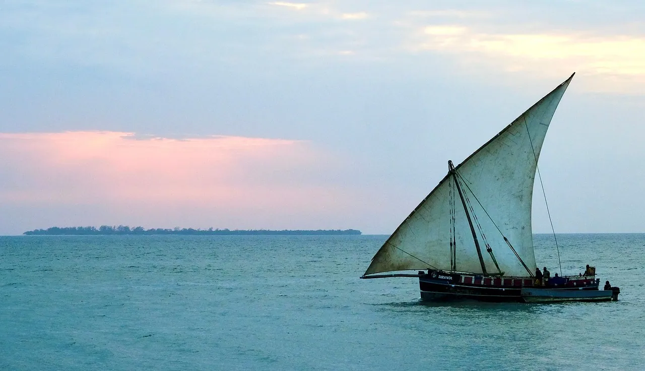 A dhow with a triangular sail on turquoise water
