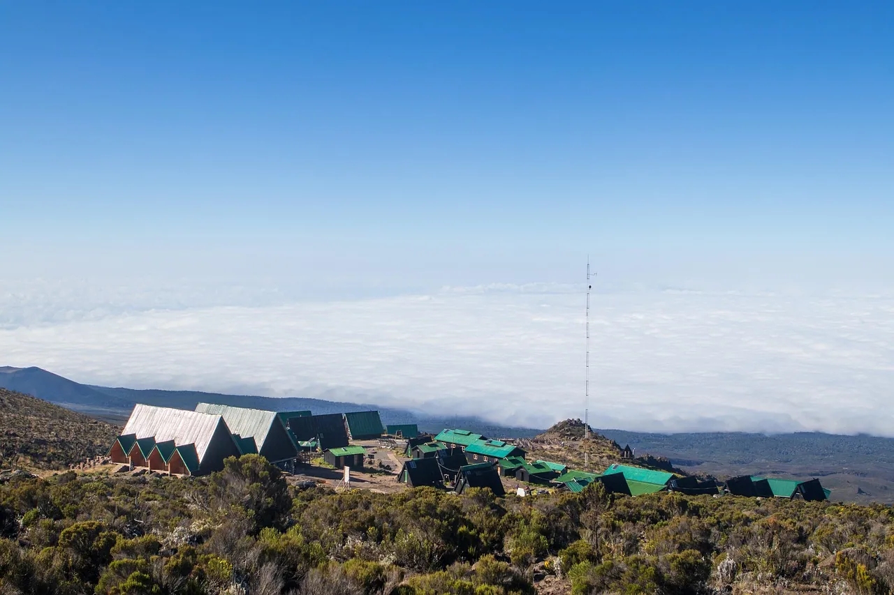 A cluster of small huts on a high ridge above the clouds