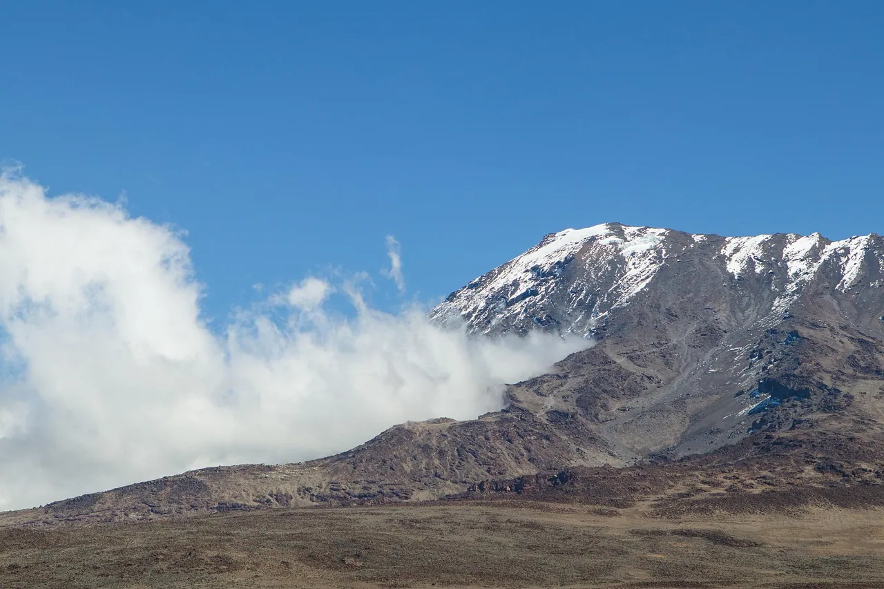 The summit of Kilimanjaro with a bank of cloud rolling past