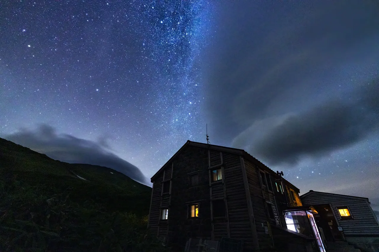 A mountain hut beneath a starry night sky