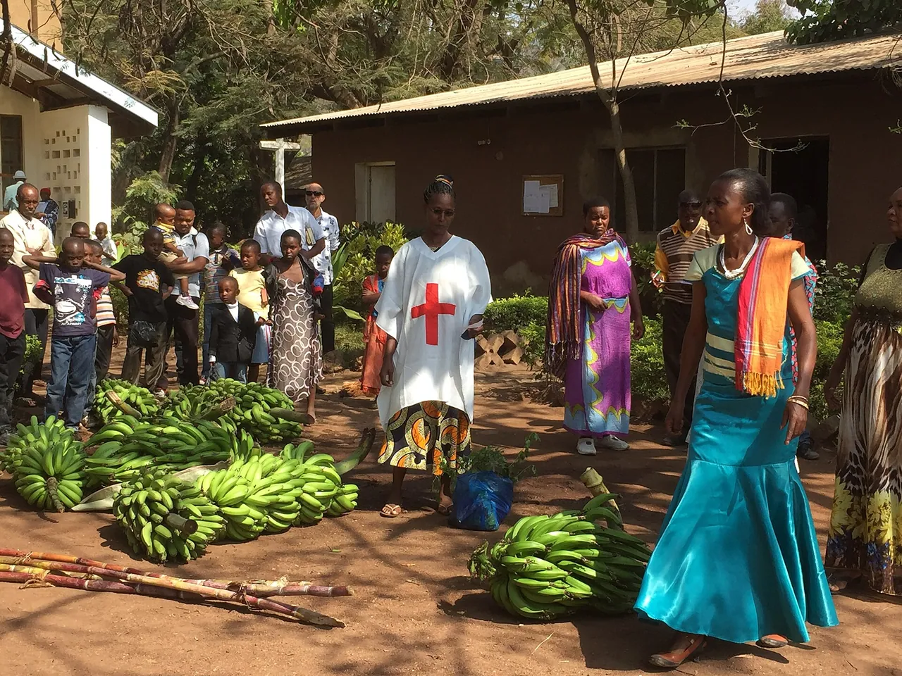 Women and children among piles of bananas at a market in Mto wa Mbu