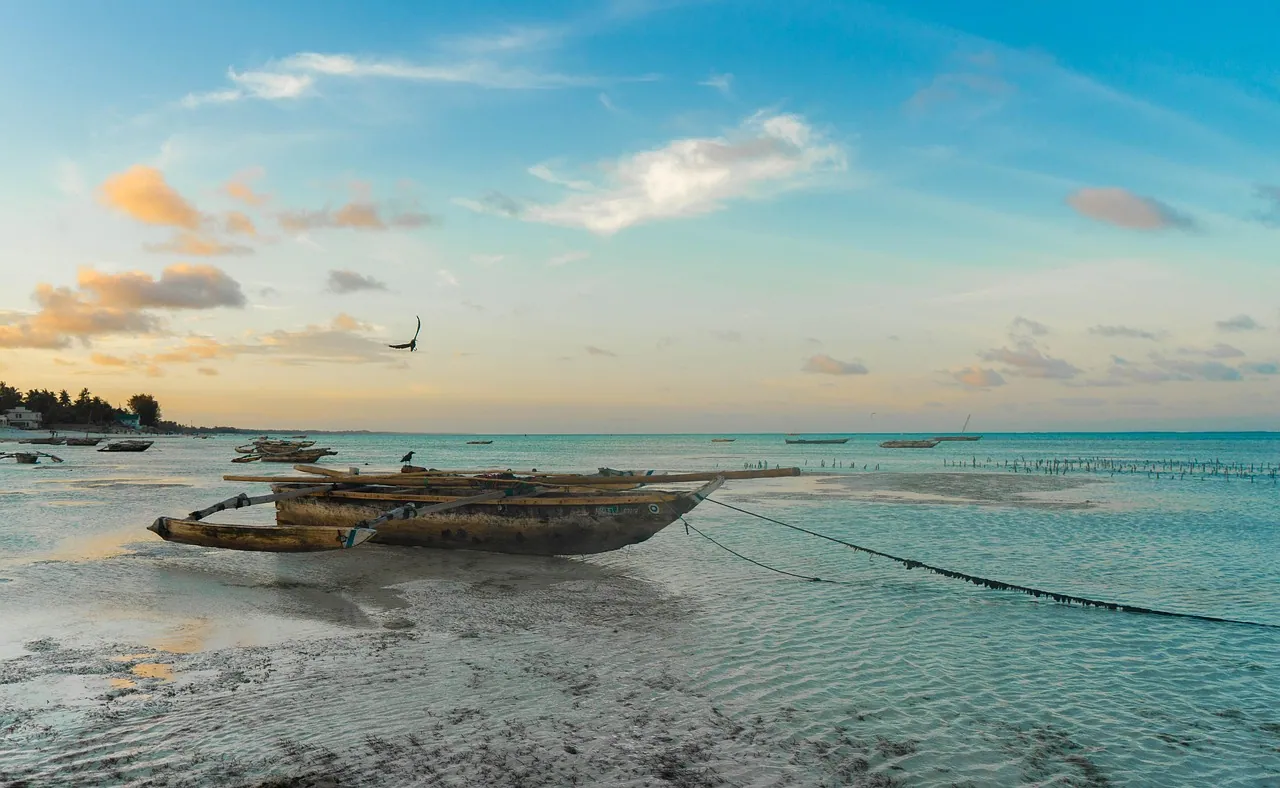 A wooden boat on a pale beach beside turquoise water