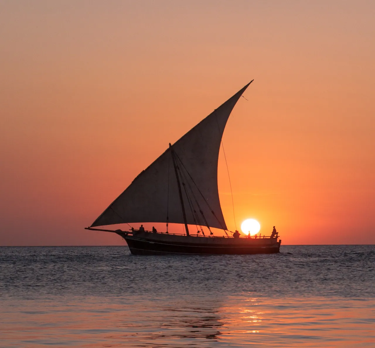 A dhow sailing against the setting sun