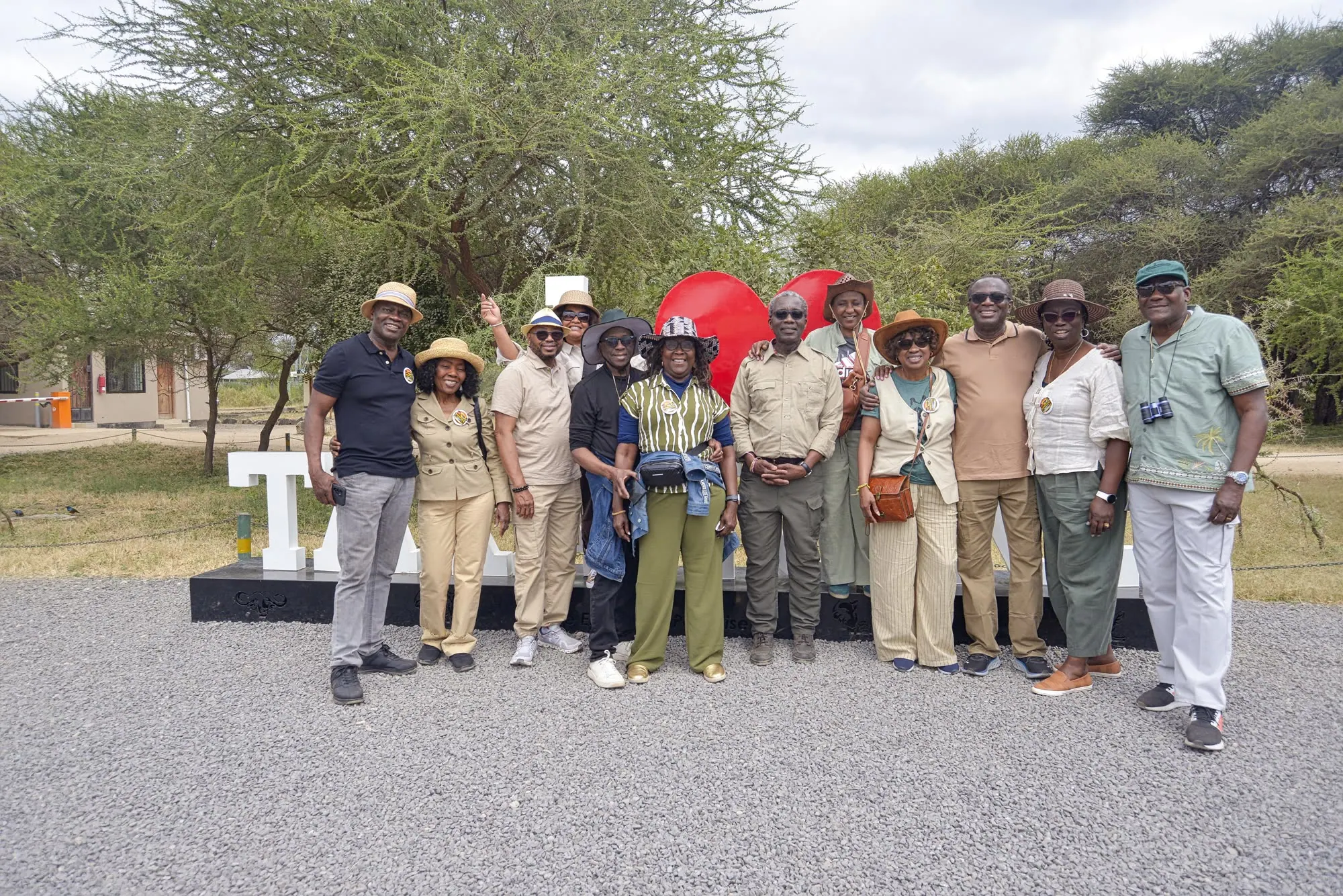 A group of guides and guests in safari clothing posing together outside a lodge entrance